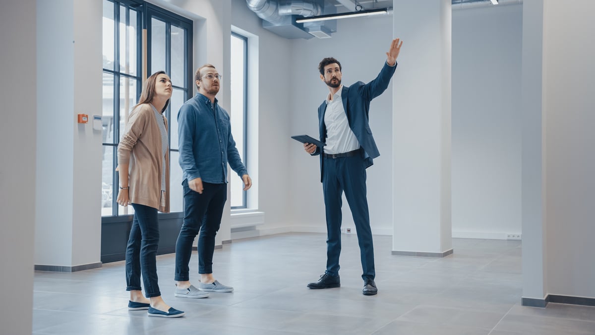 A real estate agent showing two people a commercial building