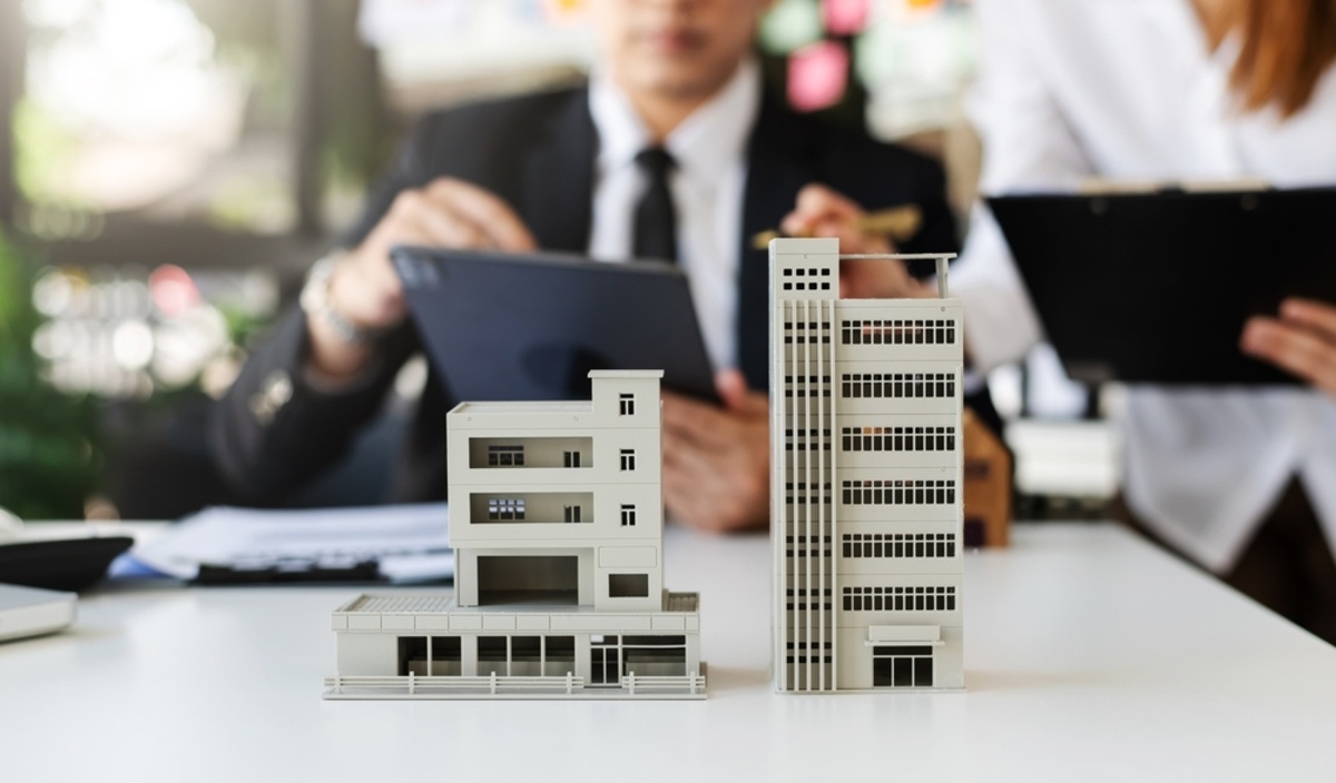 People with tablets next to model buildings