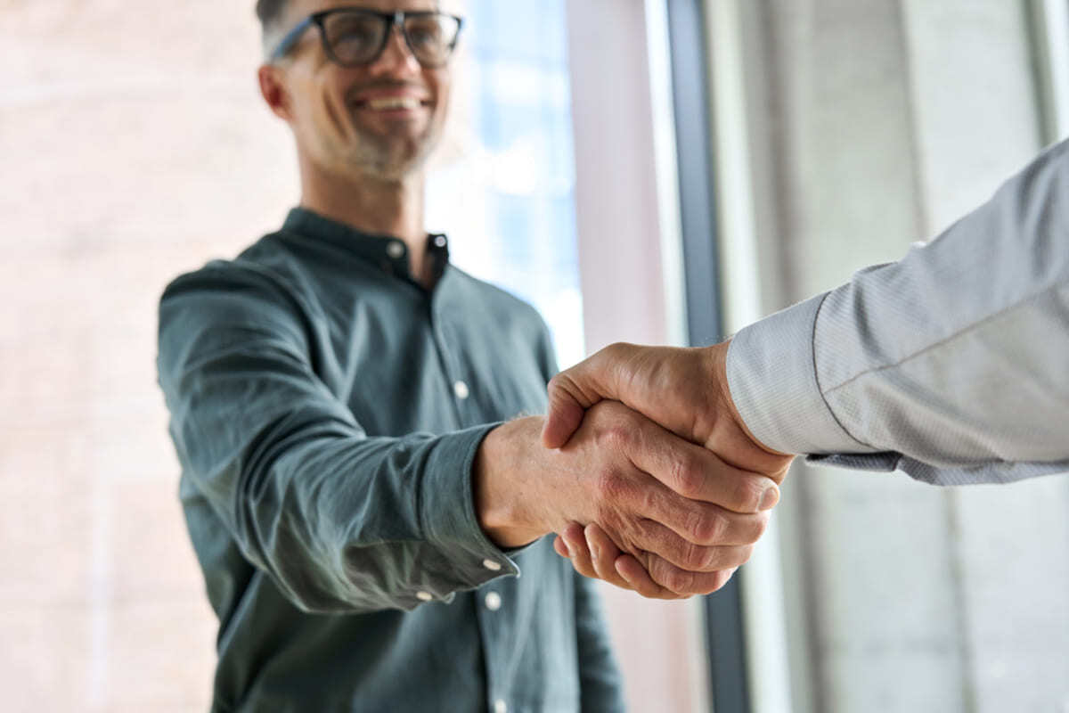 Two men shaking hands in an office space