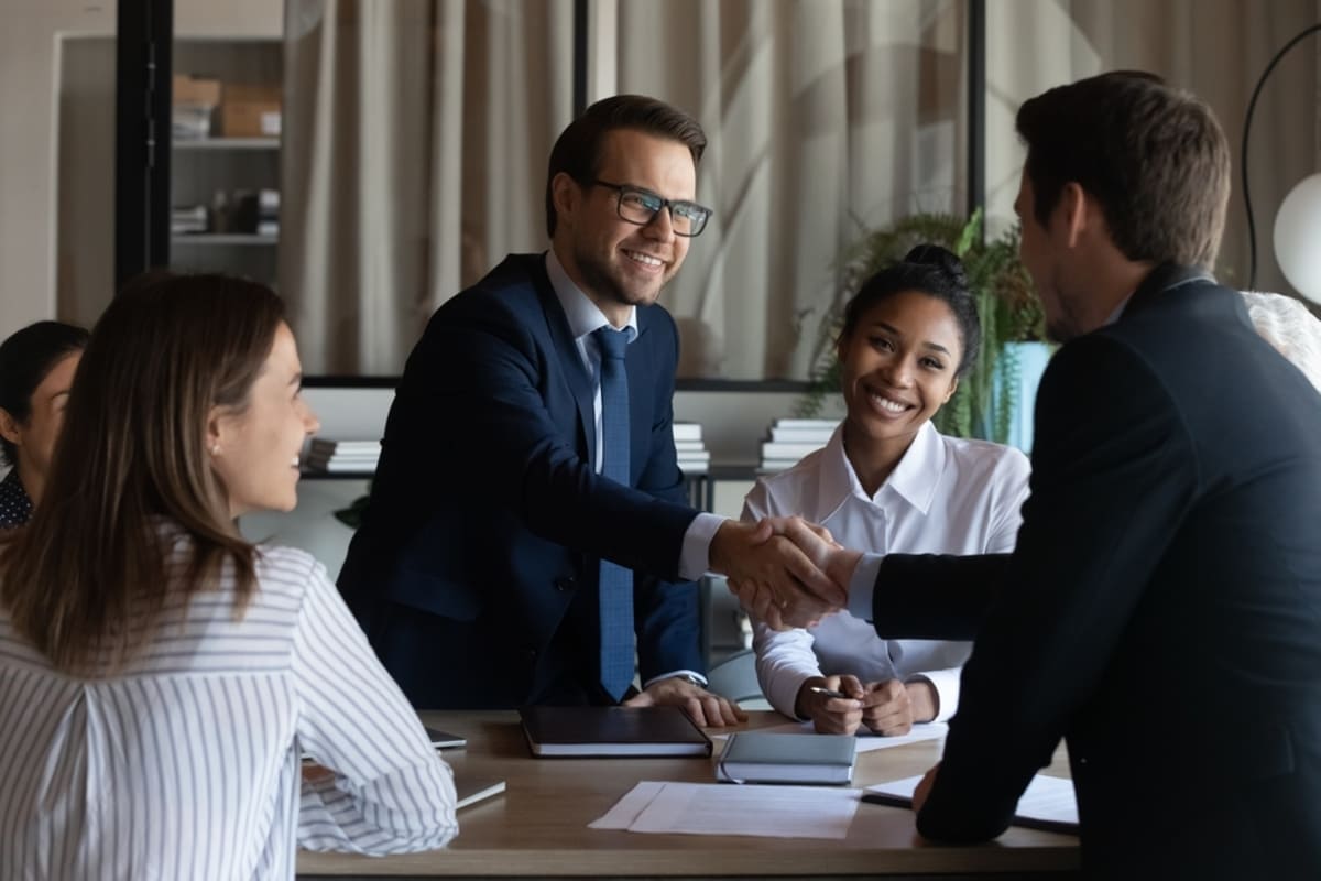 Two people shaking hands at a meeting