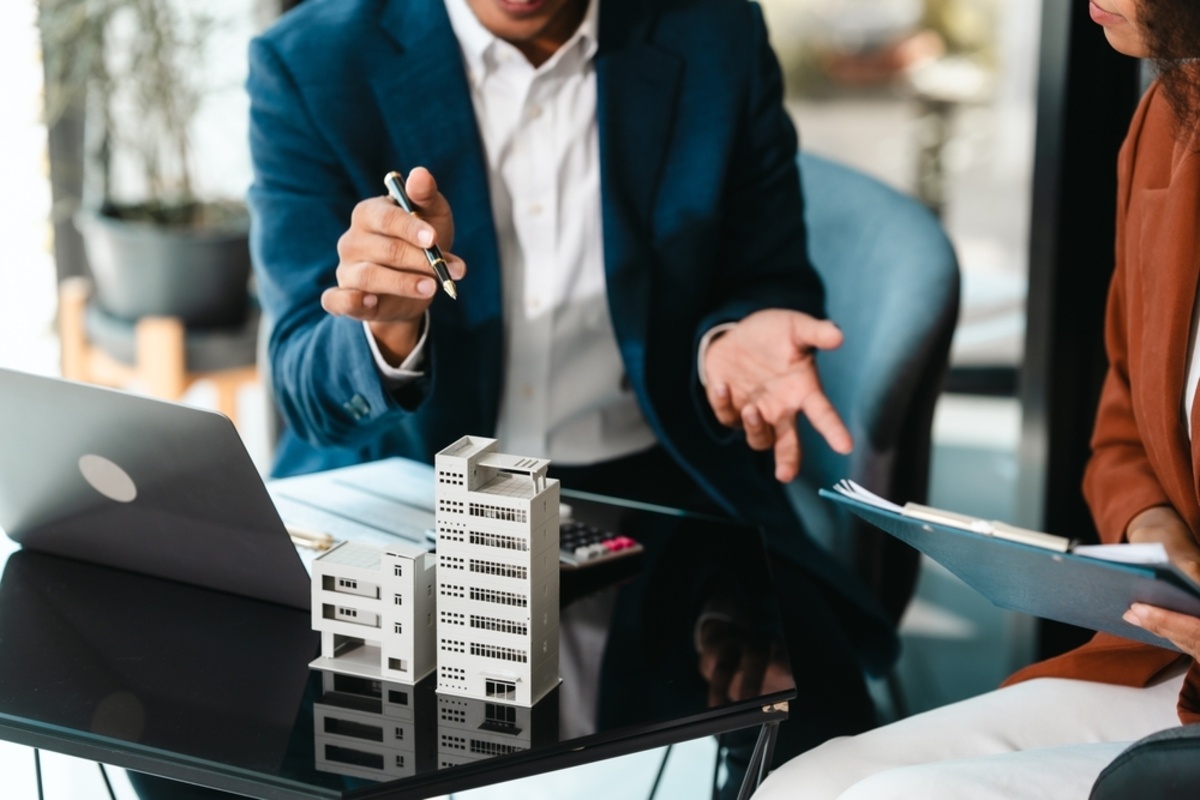 Two people working next to models of commercial buildings