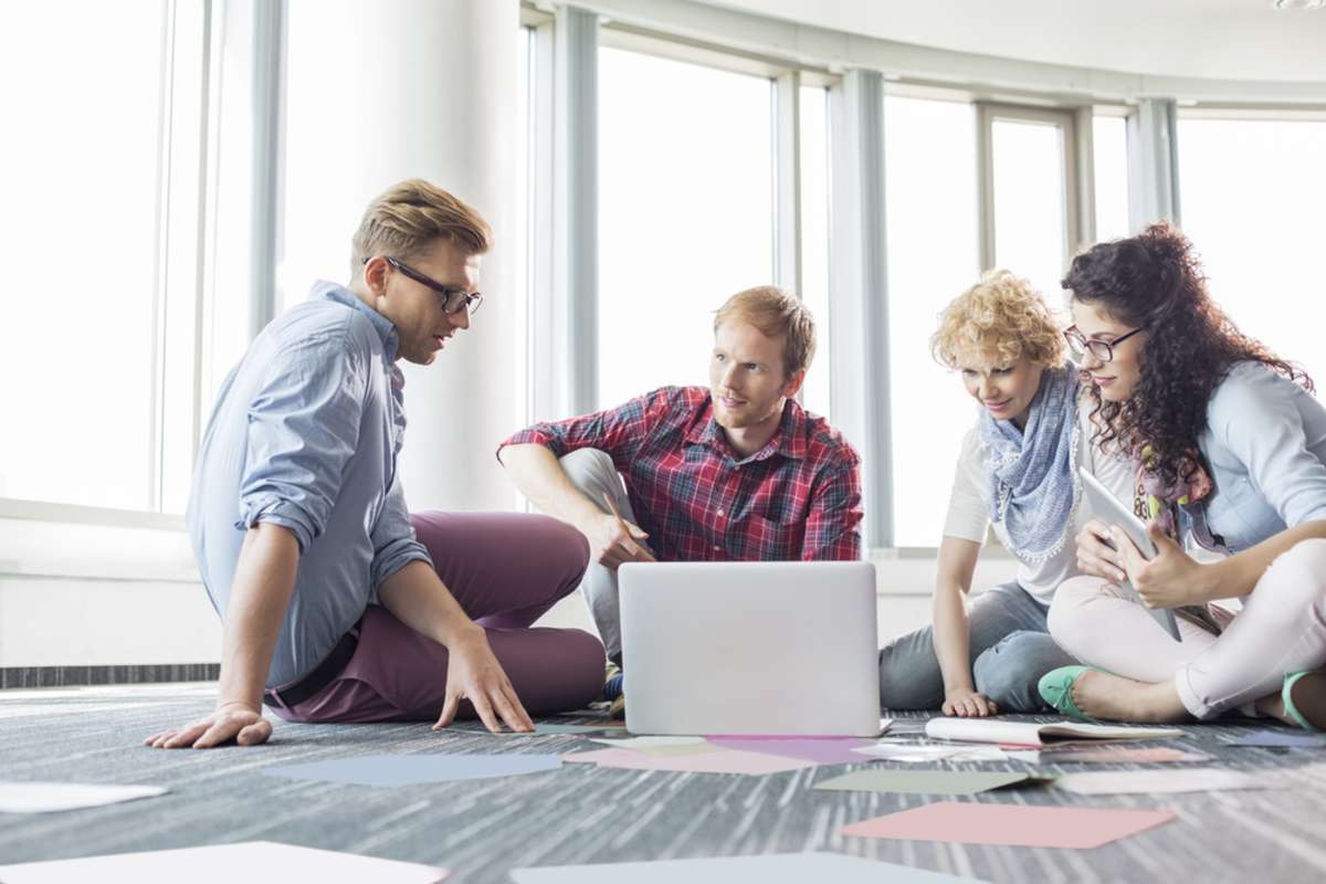 A group of business people sits on the floor discussing the potential of becoming a commercial tenant in the building