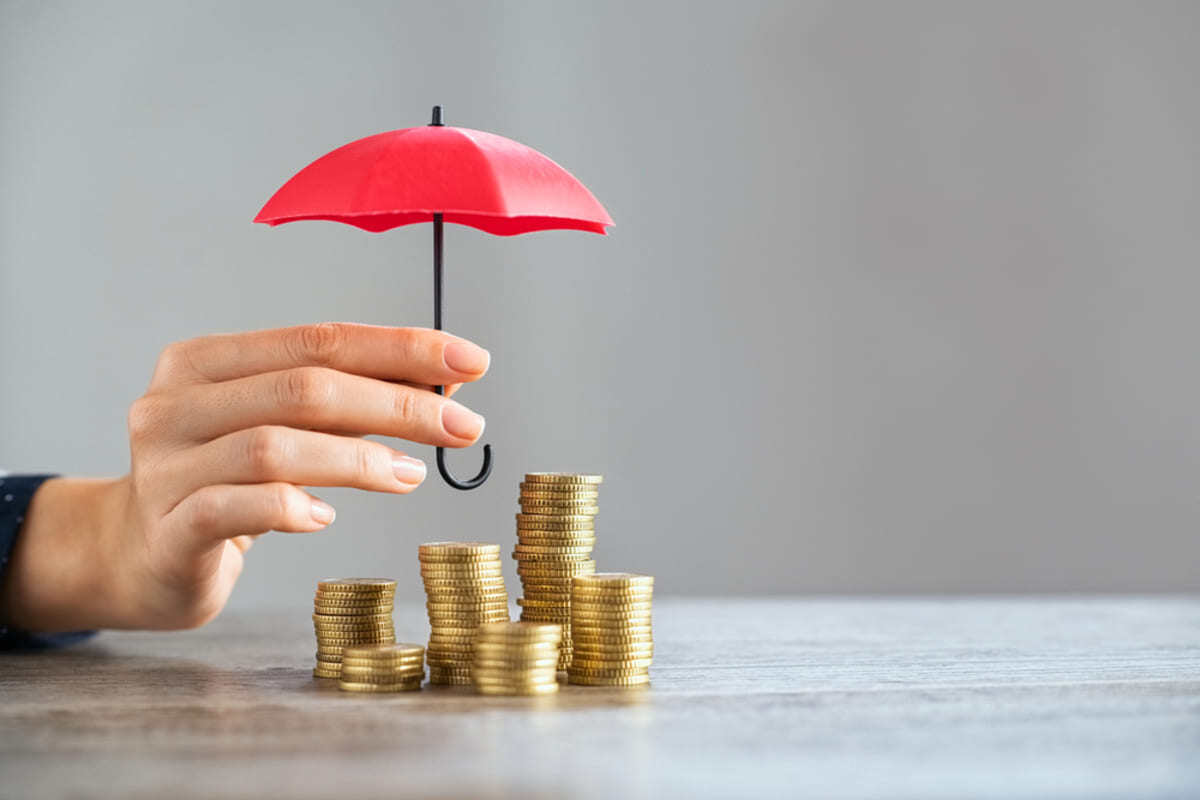 A mini umbrella over stacked coins