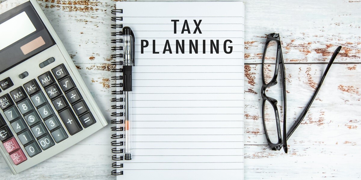 A notebook that says tax planning next to glasses and a calculator