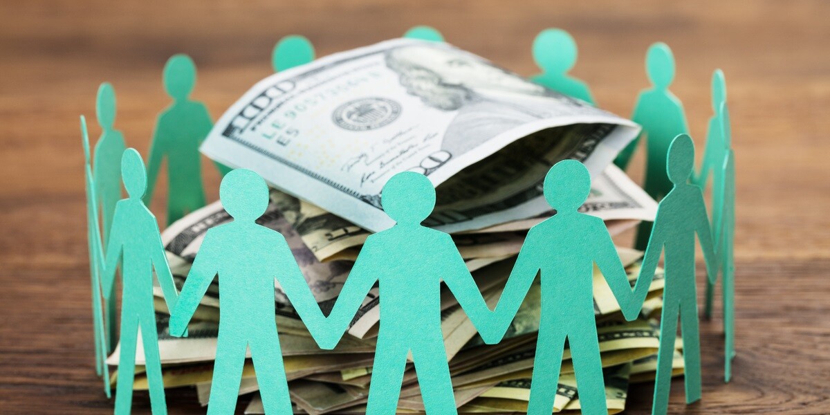 Crowdfunding Concept. Paper Cut Out Human Figures Around The Stack Of Hundred Dollar Bills