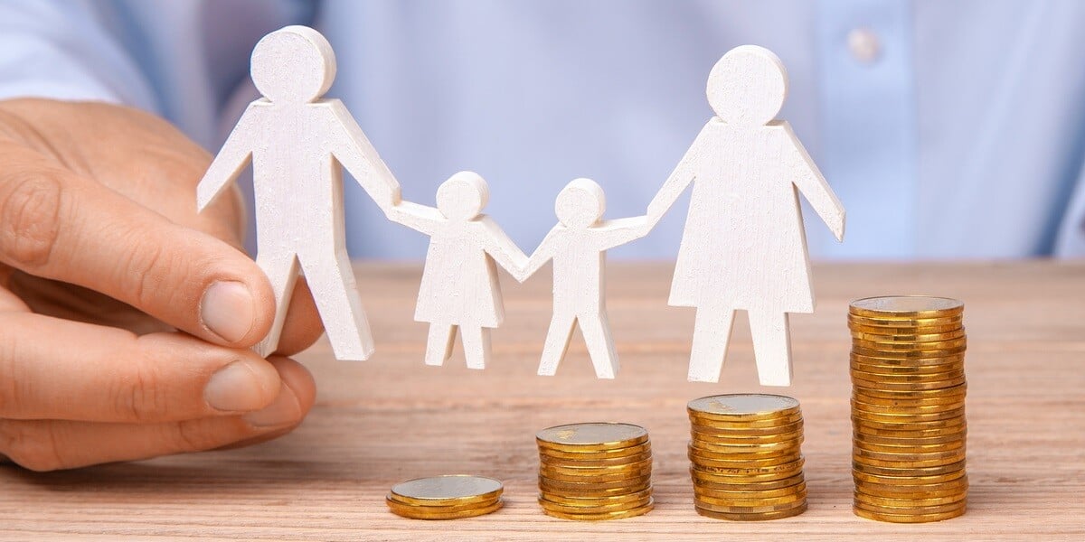 Stacked-up coins next to a cut out of a family